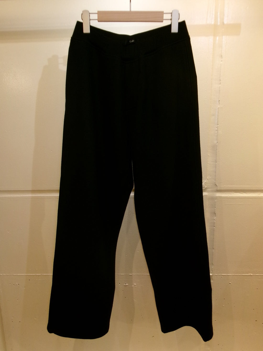 ハンガーに掛けた黒のCale Wool Straight Knit Pantsの正面